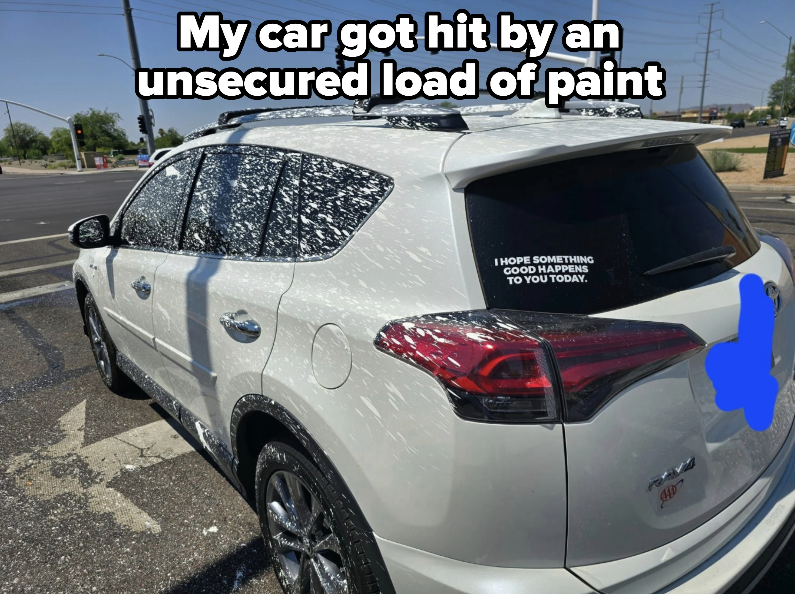 A white SUV at an intersection, covered in splattered soap, with a rear window sign reading, "I hope something good happens to you today."