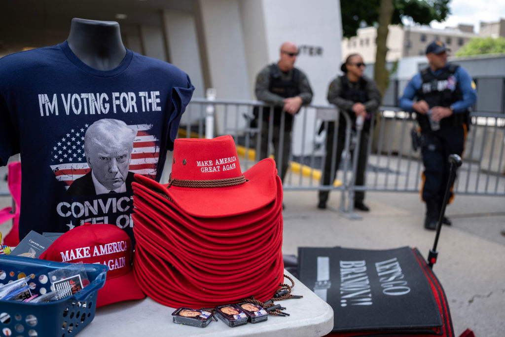 Table with &quot;Make America Great Again&quot; hats, pro-Trump merchandise, and two police officers in the background