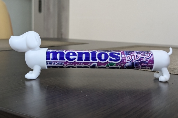 犬の形をした容器に入ったグレープ味のメントスがテーブルの上に置かれている。