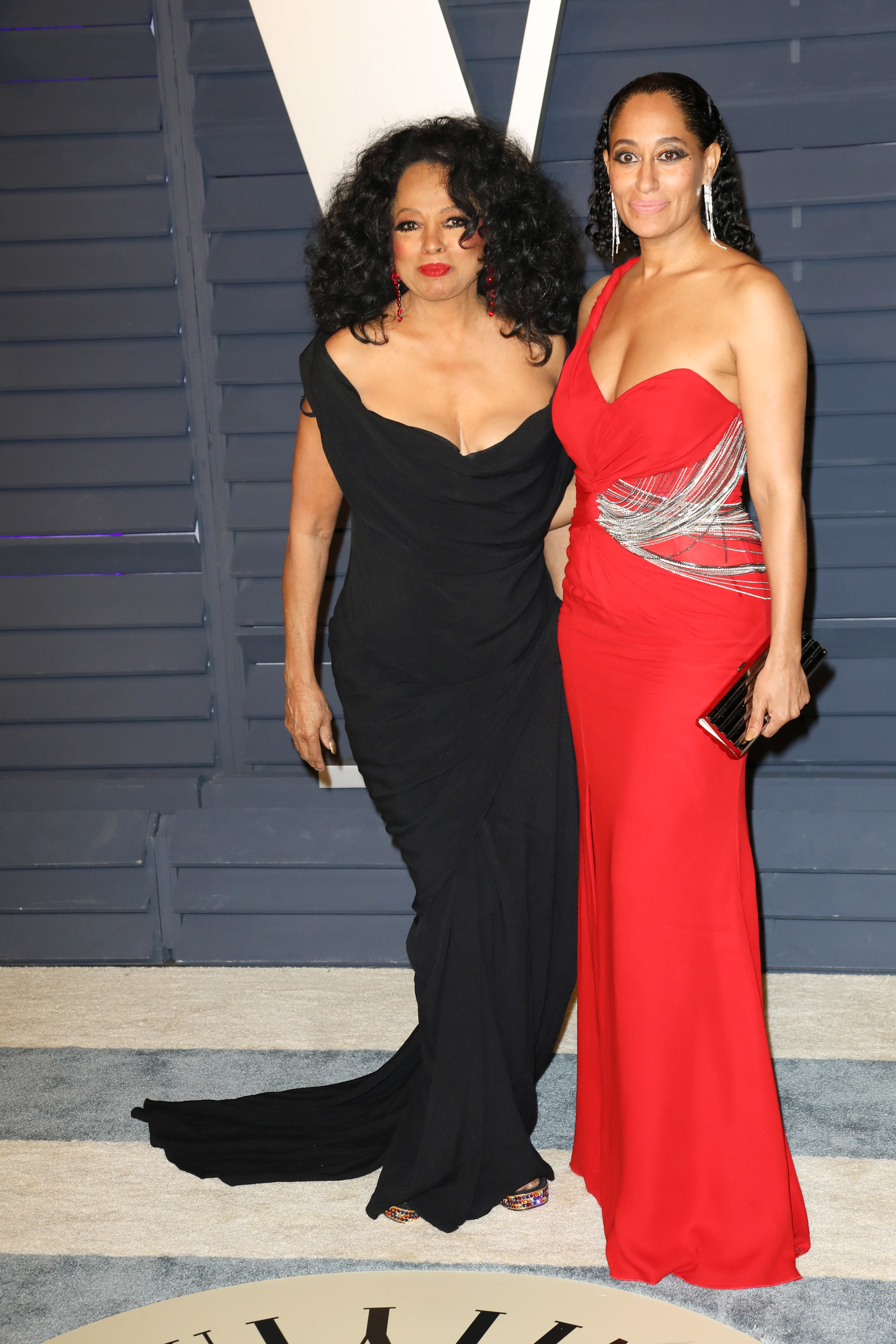 Diana Ross in an off-the-shoulder black gown and Tracee Ellis Ross in a red strapless gown with silver details at a red carpet event