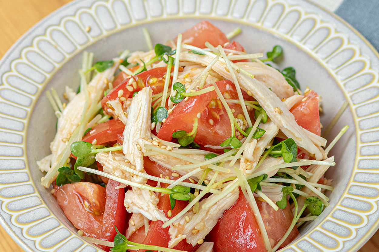 鶏肉とトマトのサラダが白い陶器のボウルに盛り付けられている。