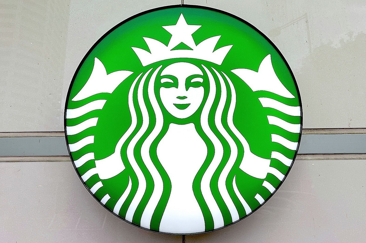 Starbucks logo featuring a white, two-tailed mermaid with a crown on a circular green background