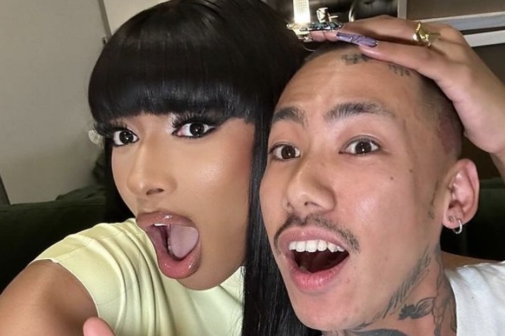 女性（メーガン・ザ・スタリオン）と男性がセルフィーを撮っている。女性はピースサインをしていて、男性は笑顔で口を開けている。