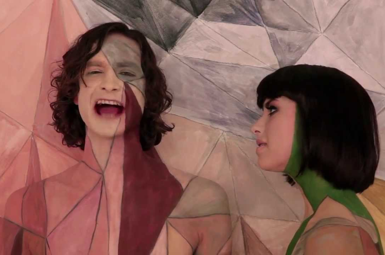Gotye and Kimbra, both body painted to blend with a geometric background, from the music video "Somebody That I Used to Know"