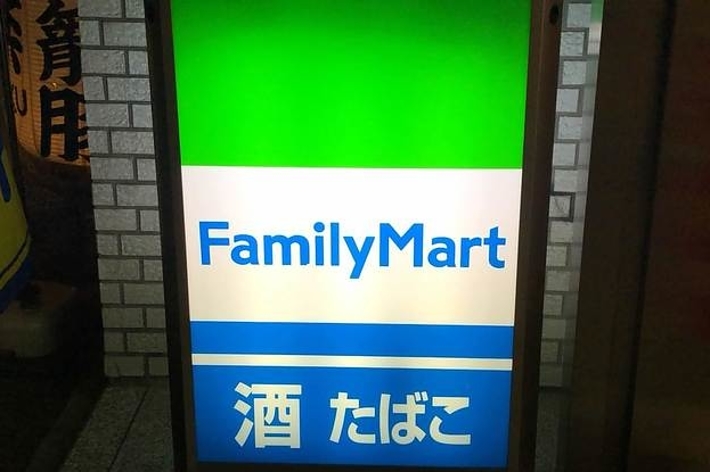 ファミリーマートの発光看板。下部に「酒 たばこ」と記載。