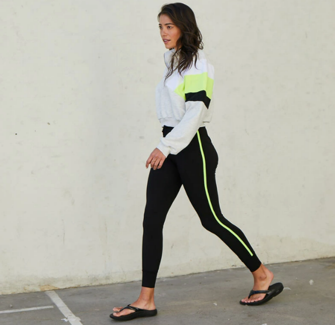 女性がスポーツウェアを着て歩いている。