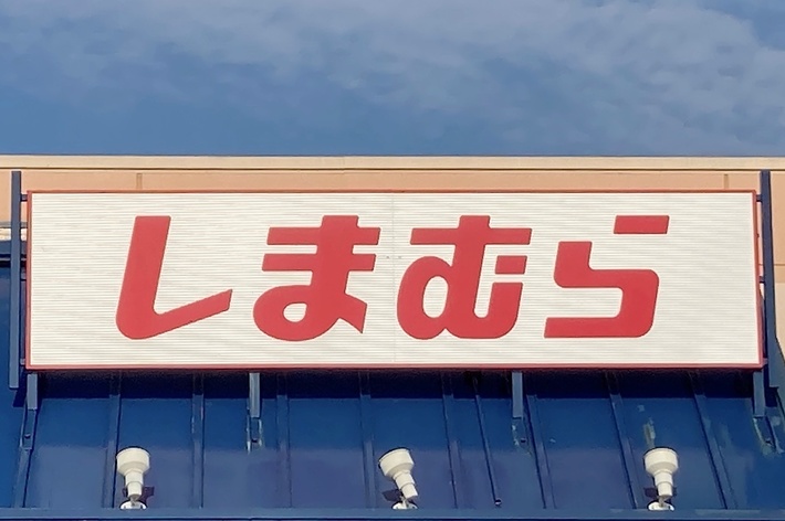 Japanese store front with the name &ldquo;Shimamura&rdquo; written in red Japanese characters on a white sign above the entrance