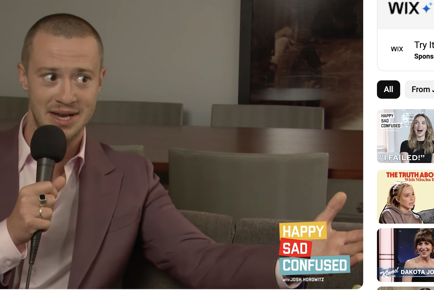 Joseph Quinn in a suit jacket during a YouTube interview