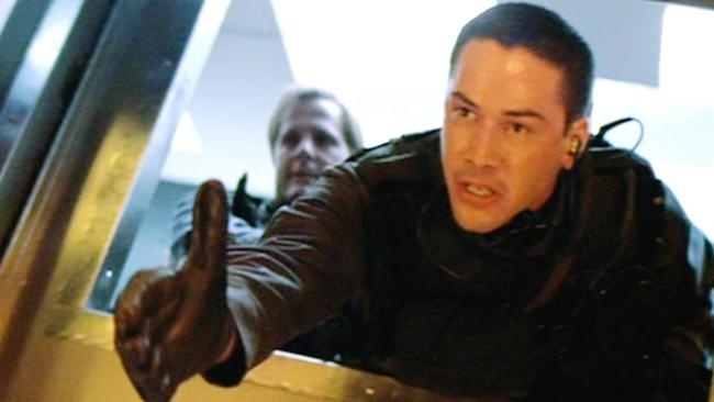 Keanu Reeves and Jeff Daniels in tactical gear, with Keanu giving a thumbs-up, from a movie scene