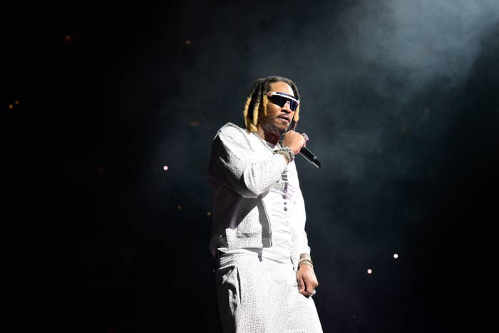 Future performing on stage, wearing a stylish patterned outfit and sunglasses, holding a microphone