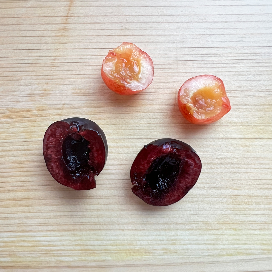 木製のまな板の上に、半分に切られた 2 つの異なる果物が置かれています。