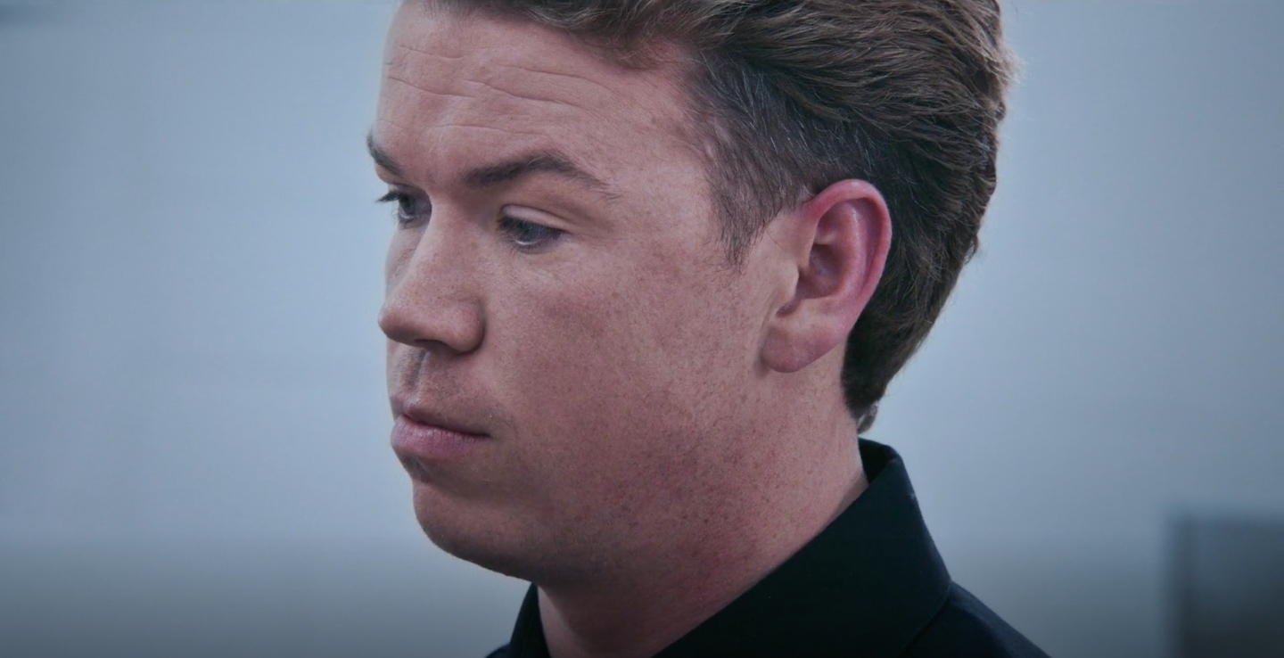 A close-up of a man with short hair looking contemplative. No additional information on identity is available