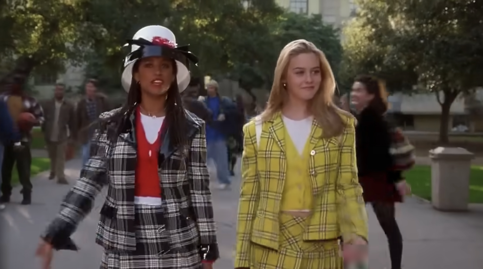 Stacey Dash and Alicia Silverstone walk together wearing stylish plaid outfits in a school setting