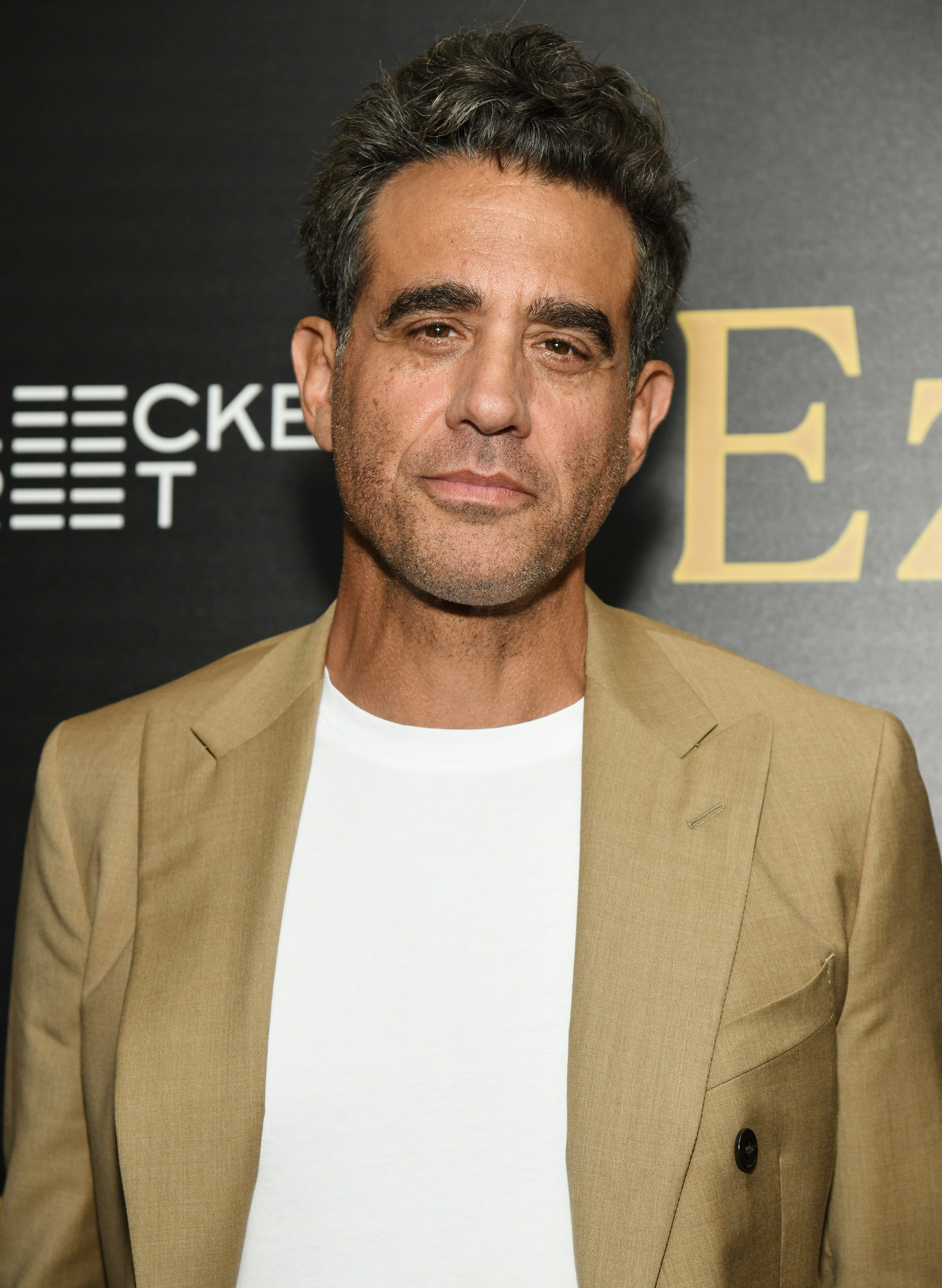Bobby Cannavale wears a white shirt under a tan blazer at the premiere of "Ezra"