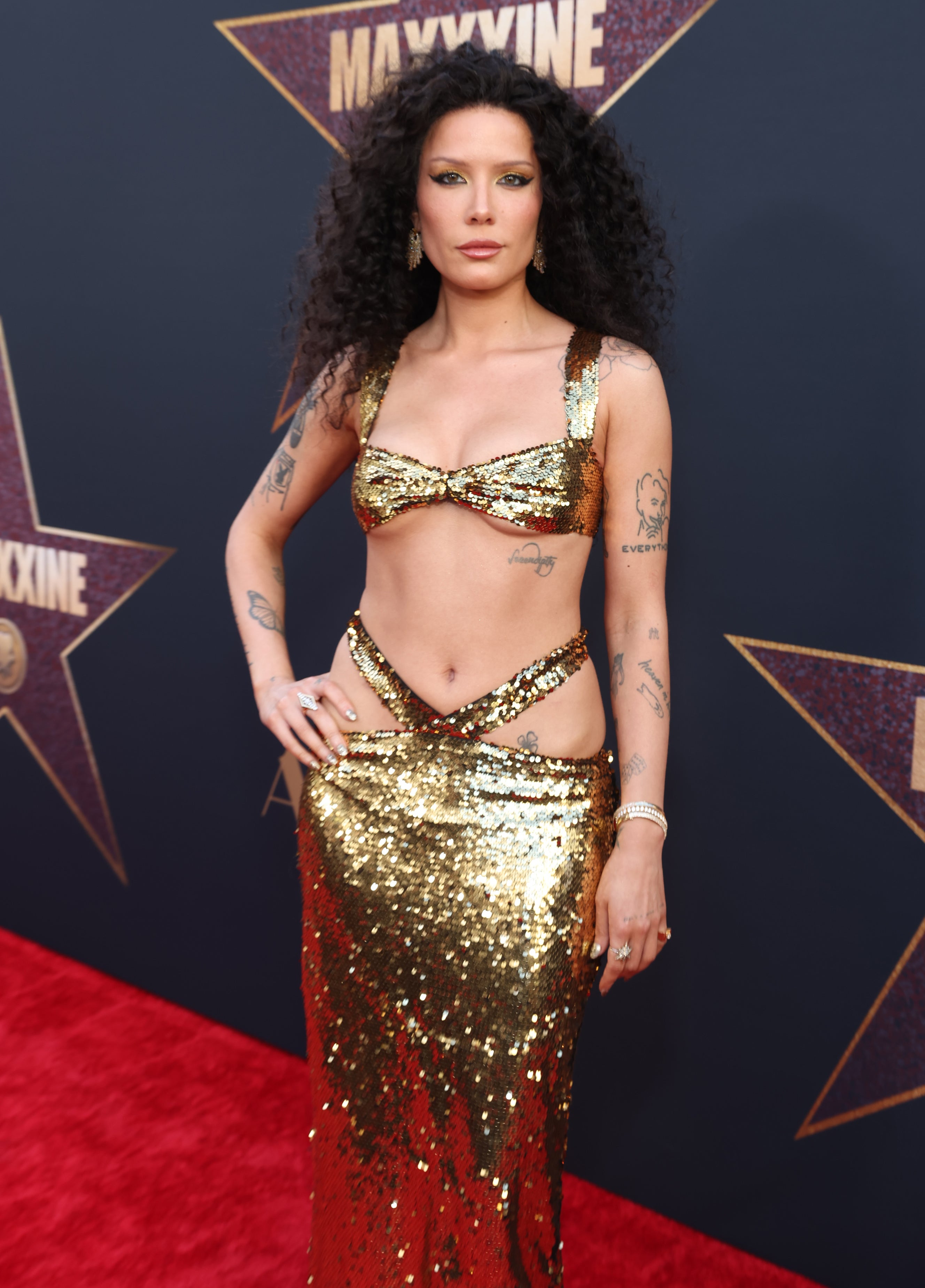 Halsey on the red carpet wearing a gold sequined two-piece dress at the premiere of "MaXXXine"