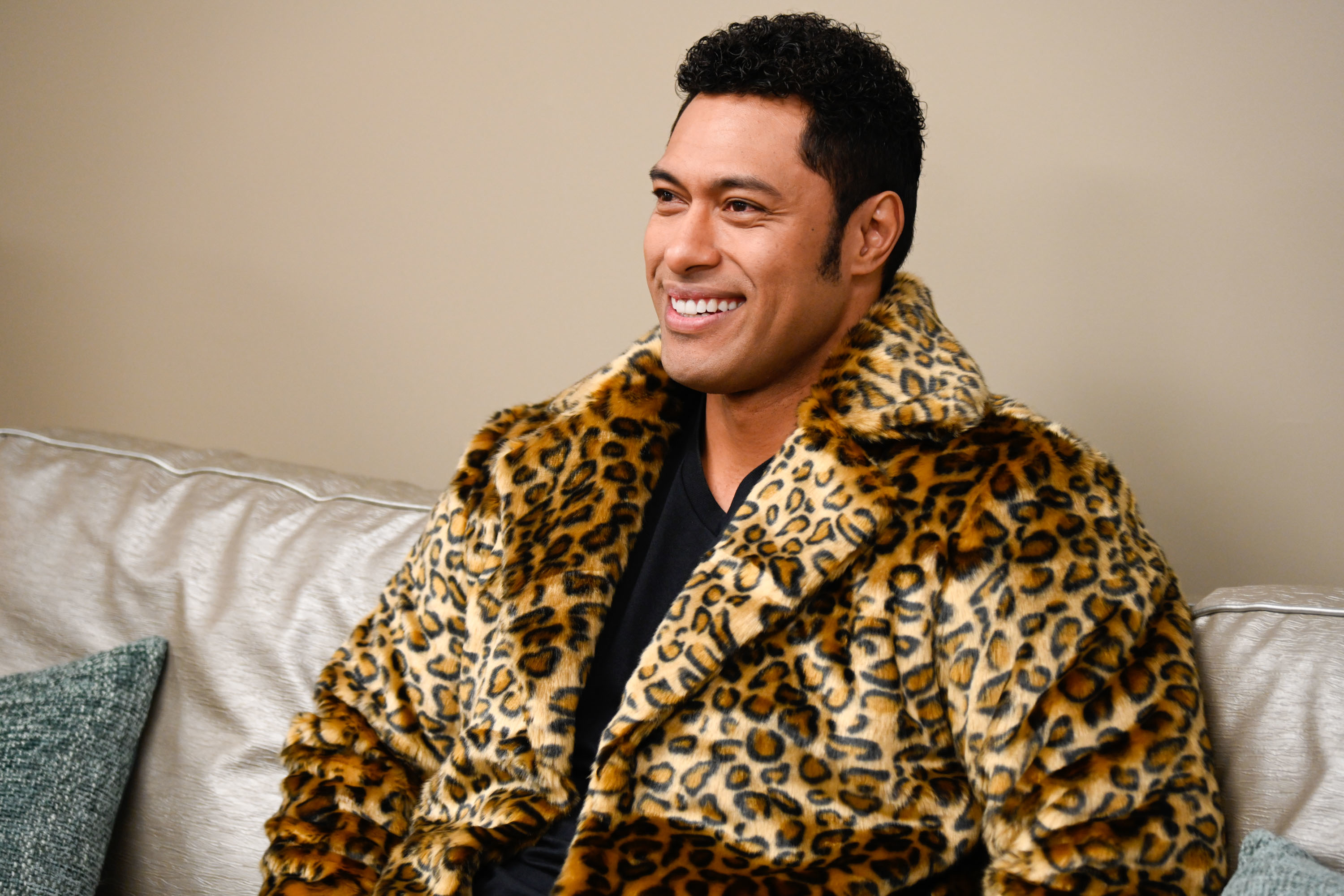 Uli Latukefu in a leopard jacket as Dwayne Johnson in a scene from "Young Rock"