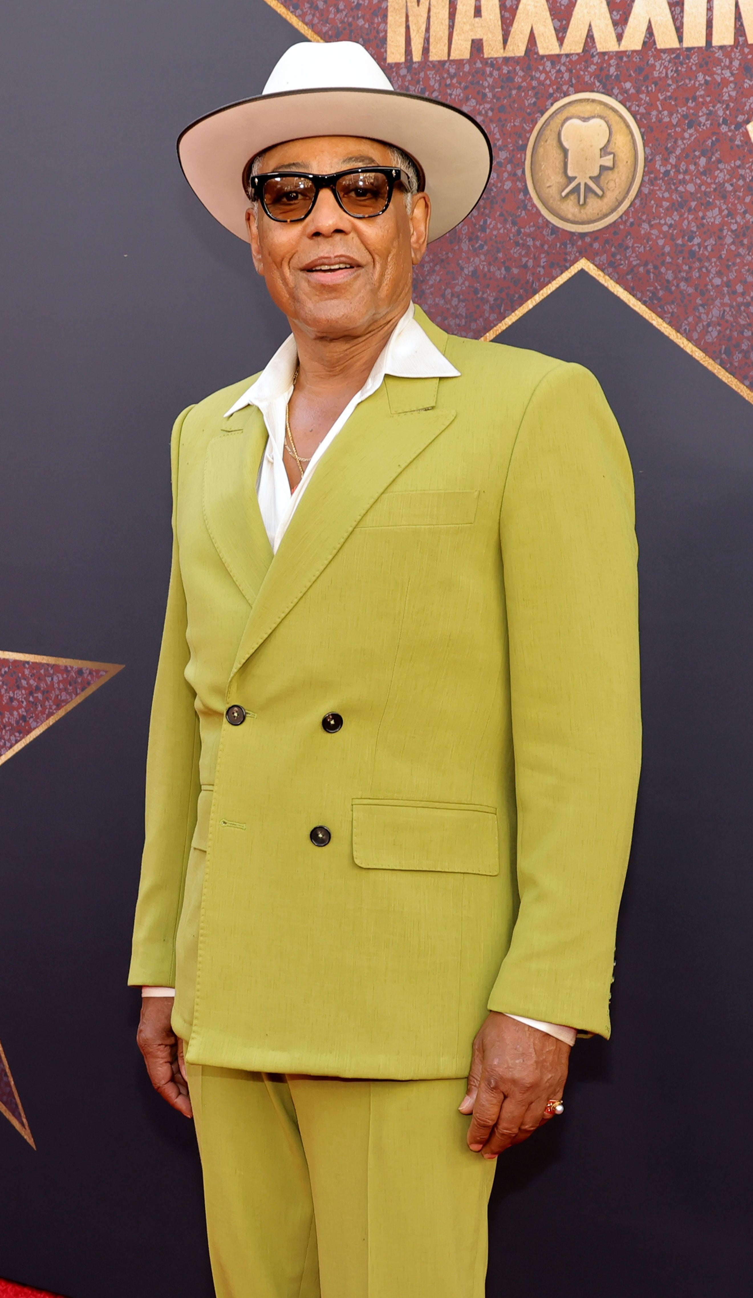 Giancarlo Esposito in a lime green suit and fedora hat the premiere of "MaXXXine"