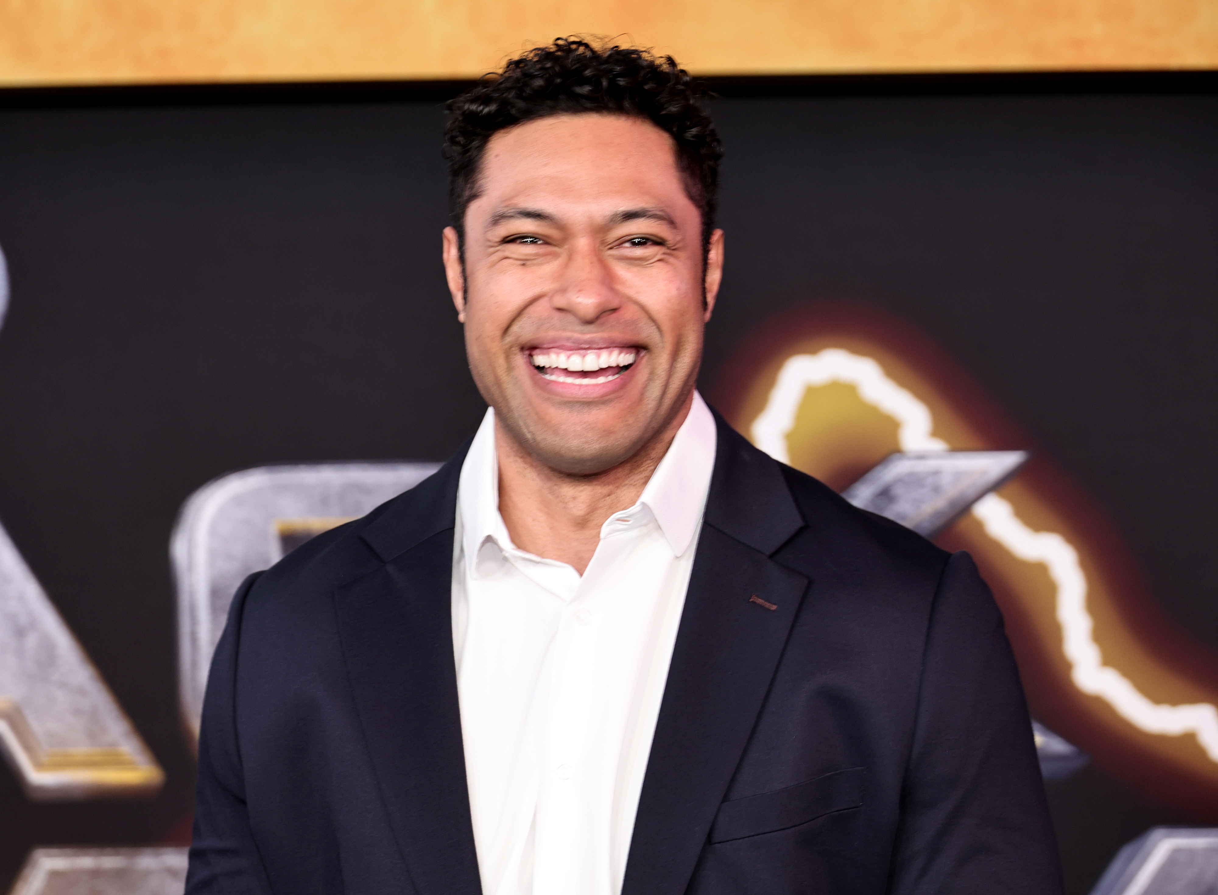 Uli Latukefu in a suit and button-up shirt at the premiere of 'Black Adam"
