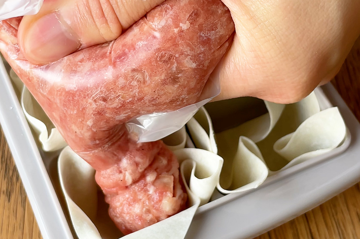 手を使ってひき肉をペーパーに入れる工程