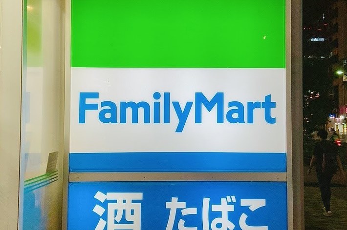 夜の通りにある「FamilyMart」の看板。看板には「酒 たばこ」と記載されています。