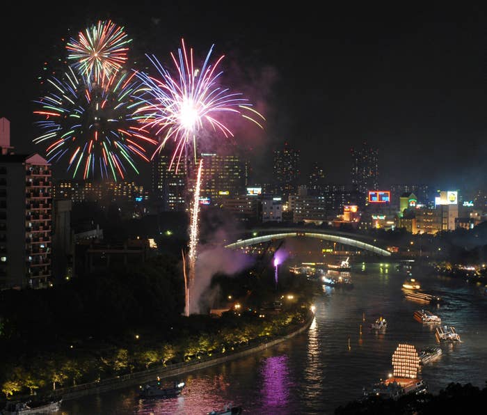 2006年の天神祭奉納花火。約100隻の祭り船が大川を往来する中で花火が大輪の花を咲かせた（時事）