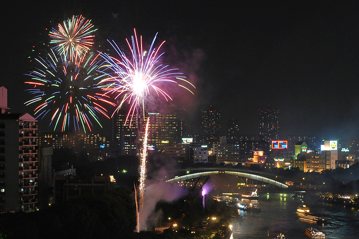 2006年の天神祭奉納花火。約100隻の祭り船が大川を往来する中で花火が大輪の花を咲かした（時事）