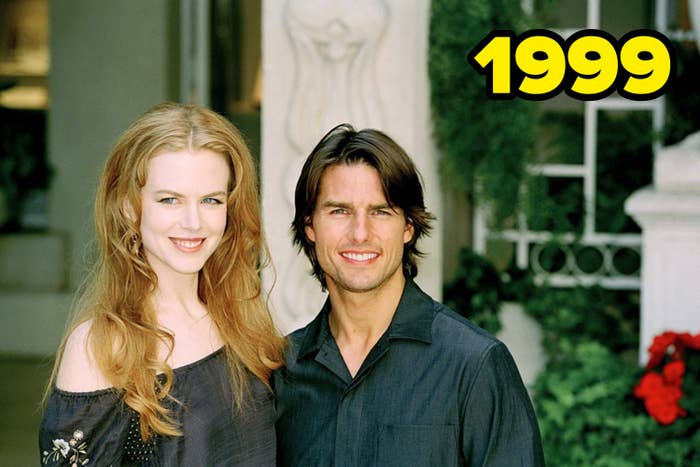 Nicole Kidman and Tom Cruise standing together, both smiling, with lush greenery in the background. Nicole wears an off-the-shoulder top and Tom wears a shirt