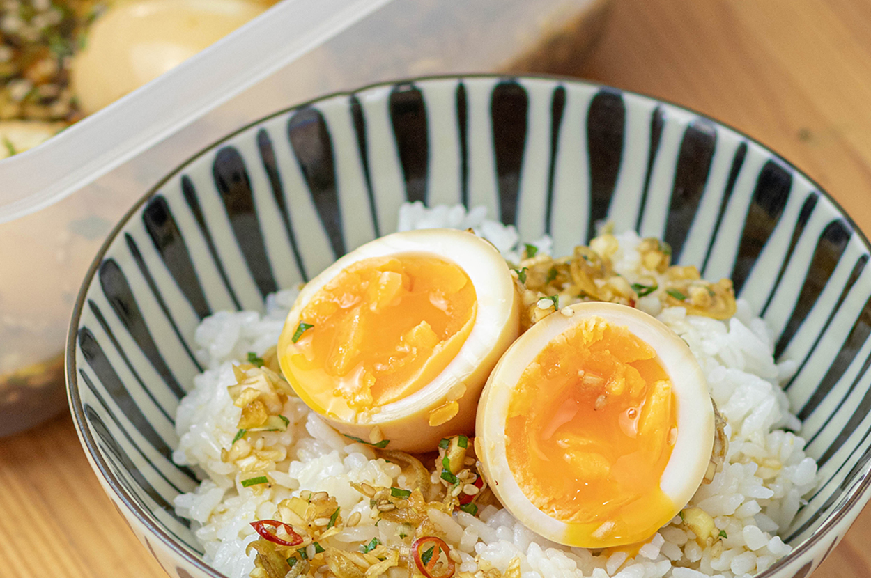 半熟卵のせご飯。プラスチック容器に多くの半熟卵が見える。