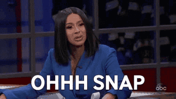 Cardi B, in a stylish outfit, raising her hands with the text overlay &quot;OH SNAP!&quot; appearing on a television show set