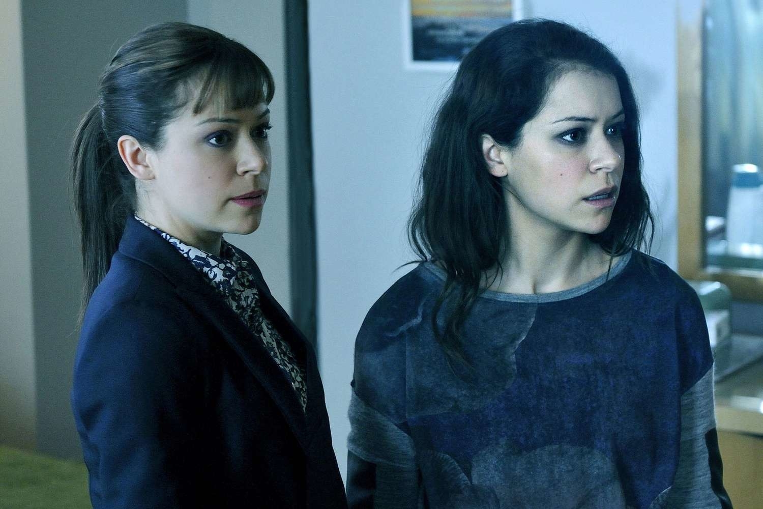 Tatiana Maslany as Sarah Manning and Tatiana Maslany as Cosima Niehaus are standing side by side, looking concerned