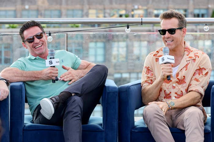 Closeup of Hugh Jackman and Ryan Reynolds sitting for a discussion