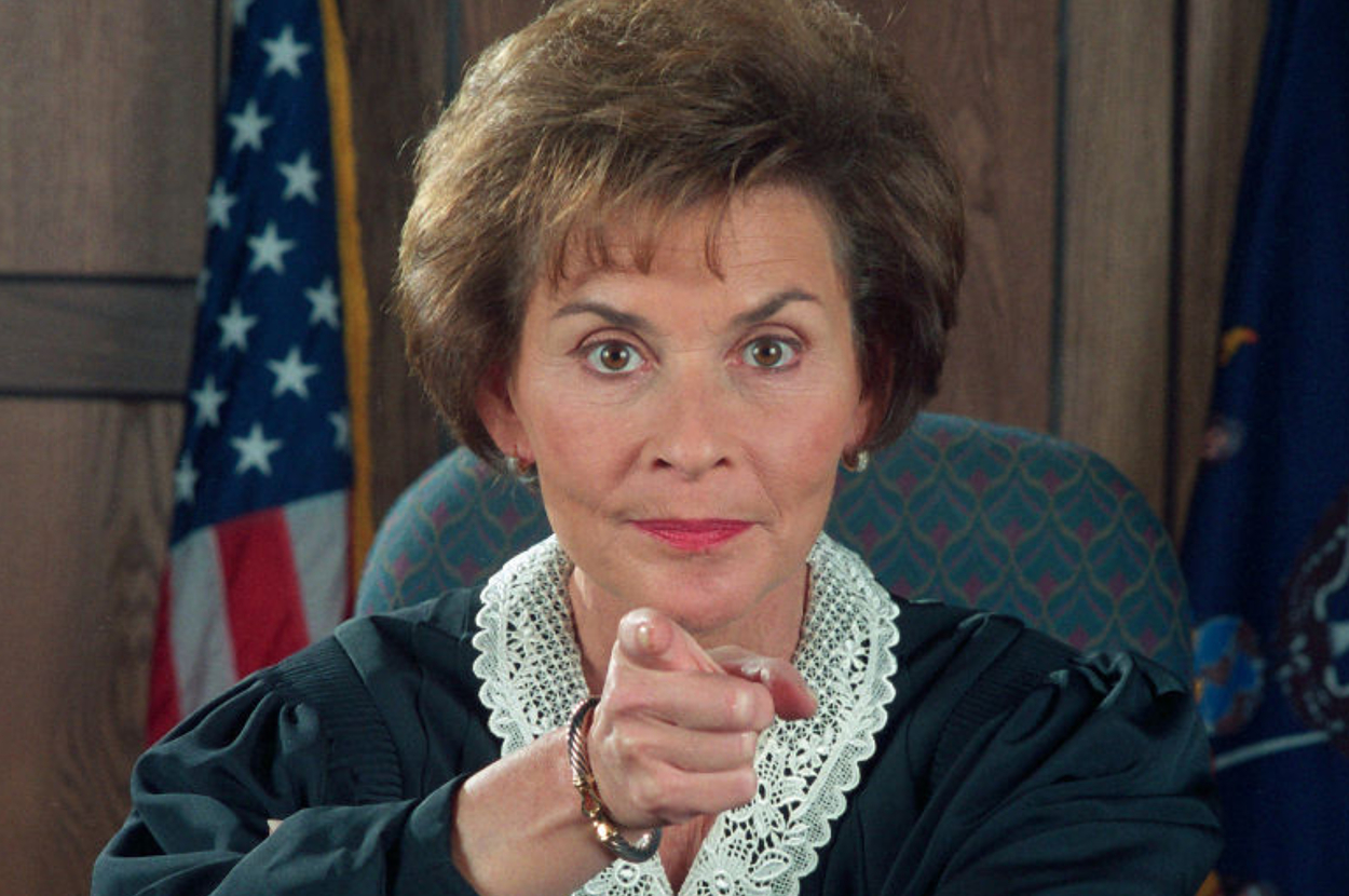 Judge Judy's expression conveys skepticism as she sits at her courtroom desk
