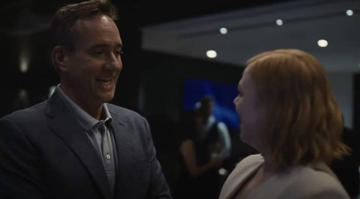 Matthew Macfadyen and Sarah Snook are smiling and talking to each other in a dimly lit room