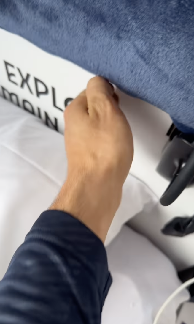 A hand gripping the outer shell of OceanGate's Titan submersible, showing part of the word "EXPLORE" visible on the side