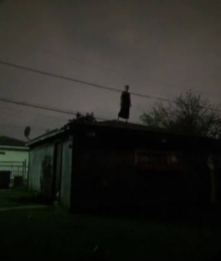 Person standing on the roof of a building at night