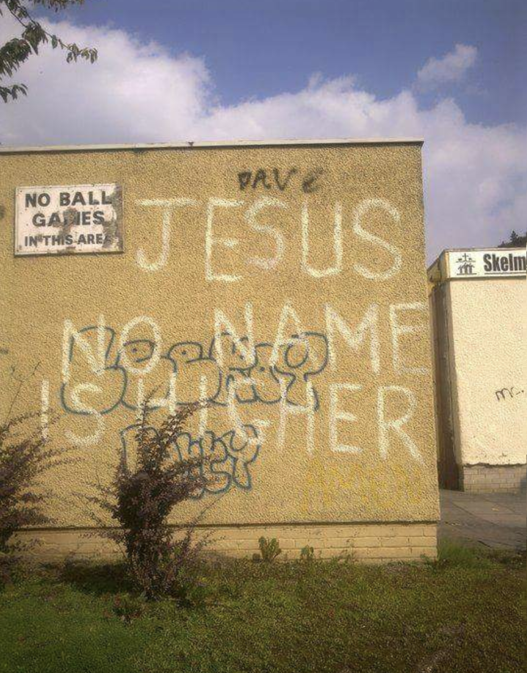 Graffiti on a building reads, "JESUS NO NAME IS HIGHER" "Dave" is scrawled above it