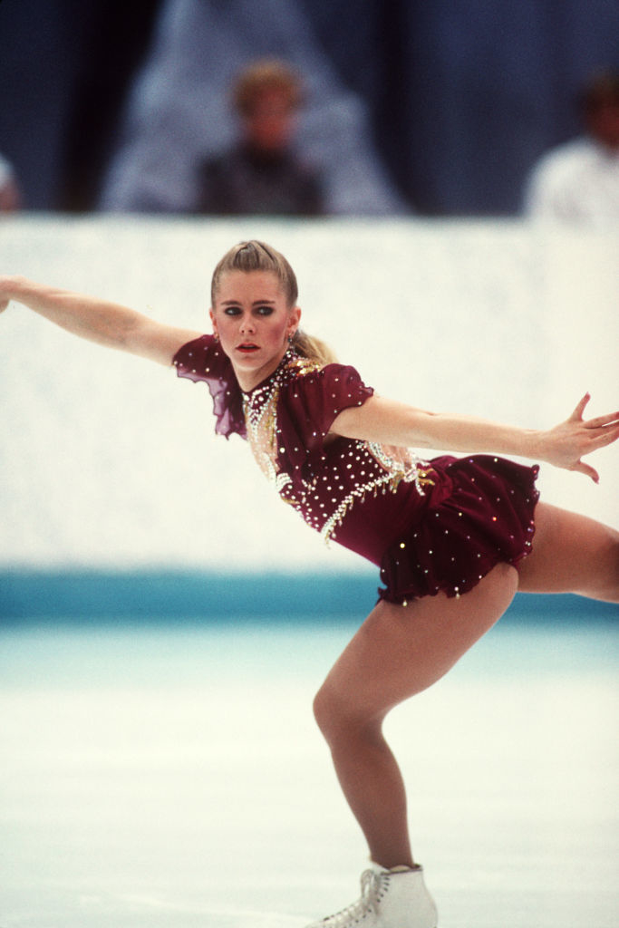 Tonya Harding performs a figure skating routine on the ice wearing a sequined figure skating outfit with sheer shoulder details