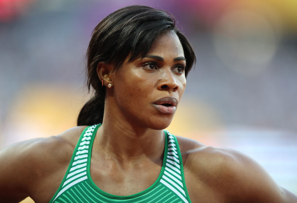 Blessing Okagbare on a stadium track wearing an athletic tank top with white stripes