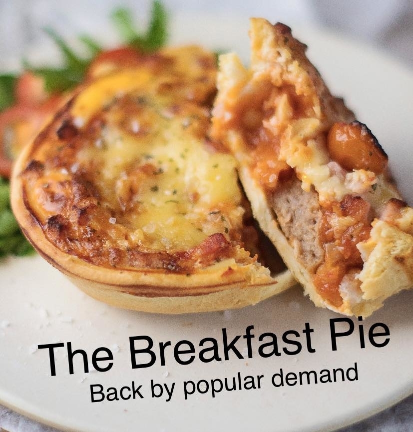Close-up of a breakfast pie with meat and vegetables, served on a white plate with garnish. Text reads "The Breakfast Pie - Back by popular demand."