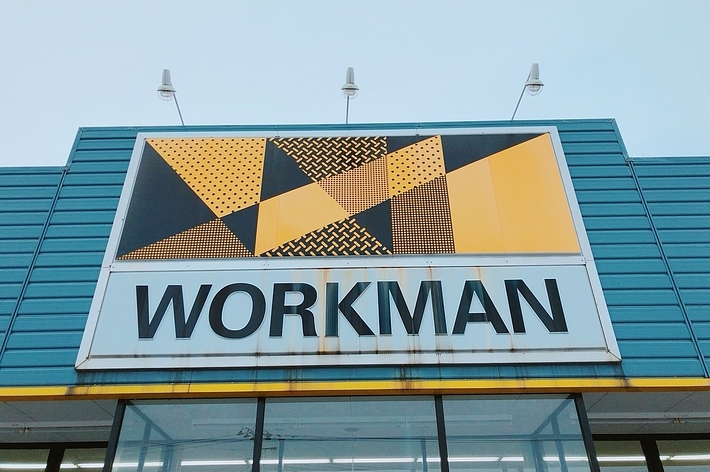 Sign above a store entrance reads &ldquo;WORKMAN&rdquo; with geometric patterns above the text