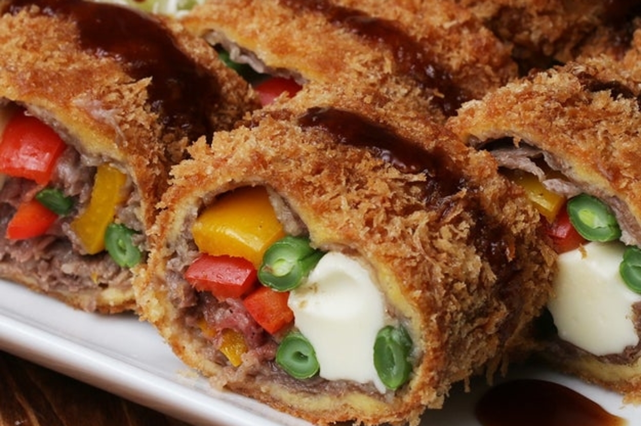 皿に盛られたカラフルな野菜とチーズが入った揚げ物と千切りキャベツが並んでいます。