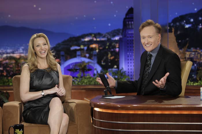 Lisa Kudrow and Conan O'Brien share a laugh during an interview on Conan's late-night talk show set