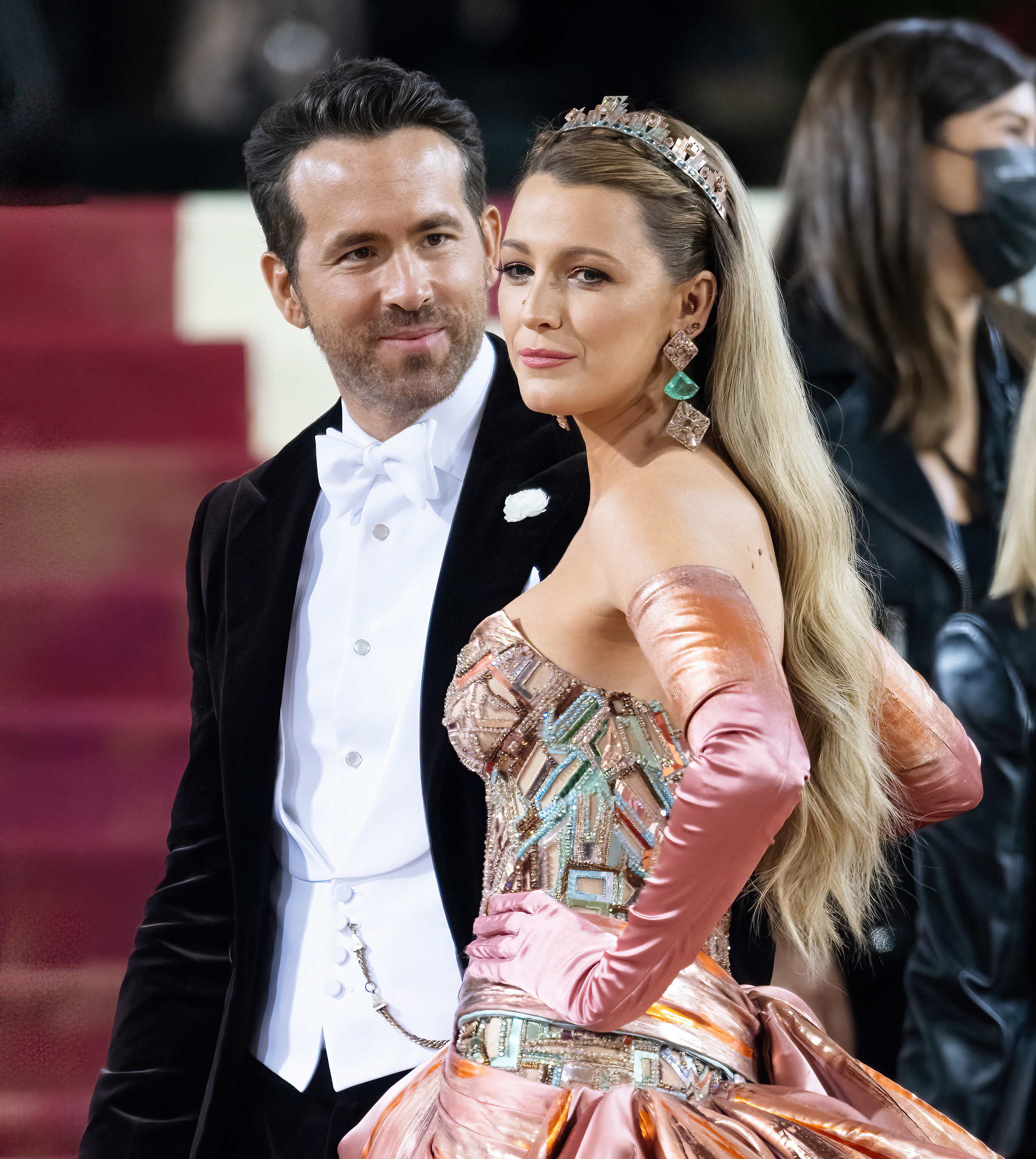 Ryan Reynolds in a tuxedo and Blake Lively in a glamorous gown pose on the red carpet