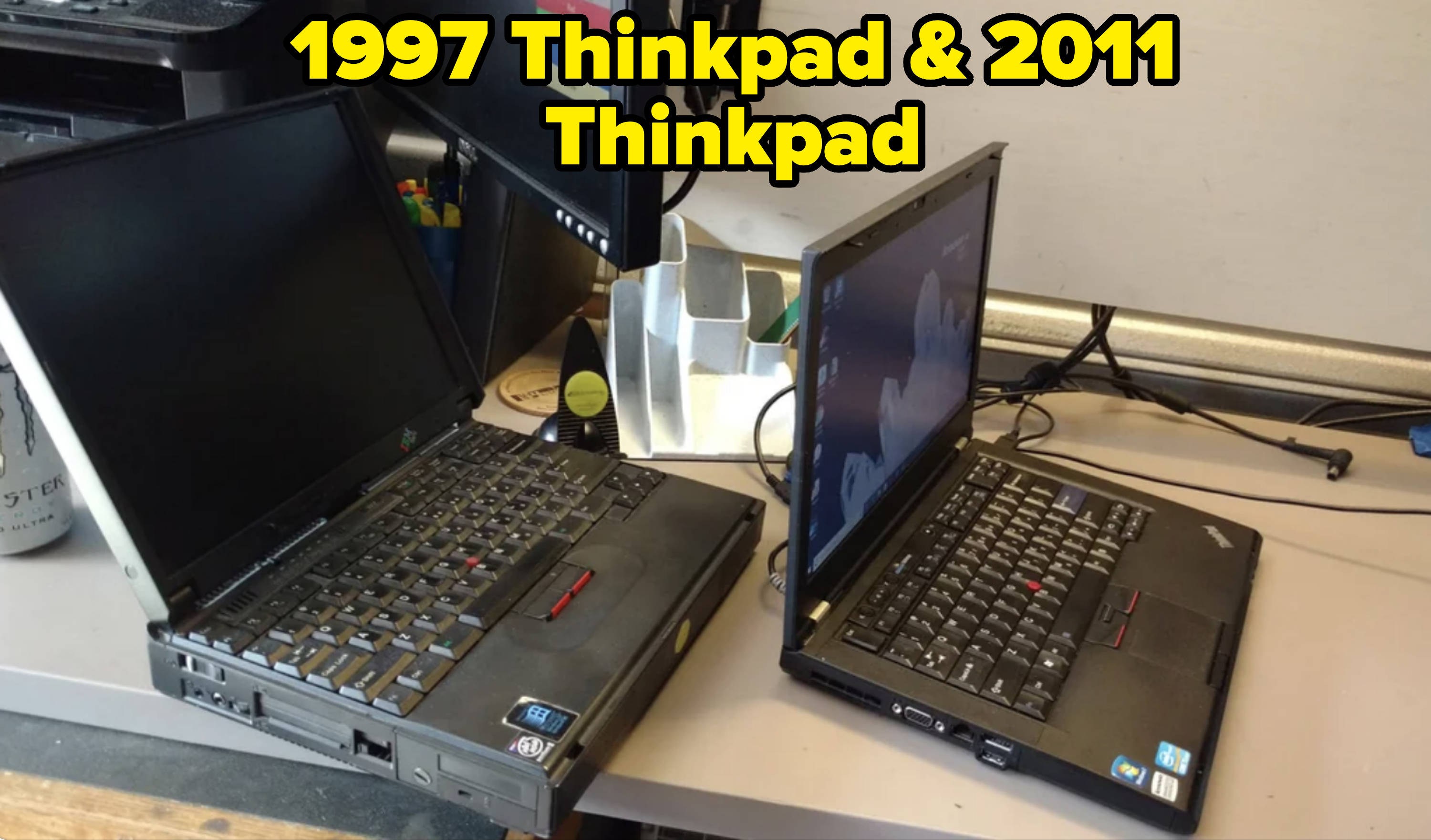 Two black IBM ThinkPad laptops are open and positioned on a desk. One laptop is slightly larger, and they are set up for possible repairs or comparison