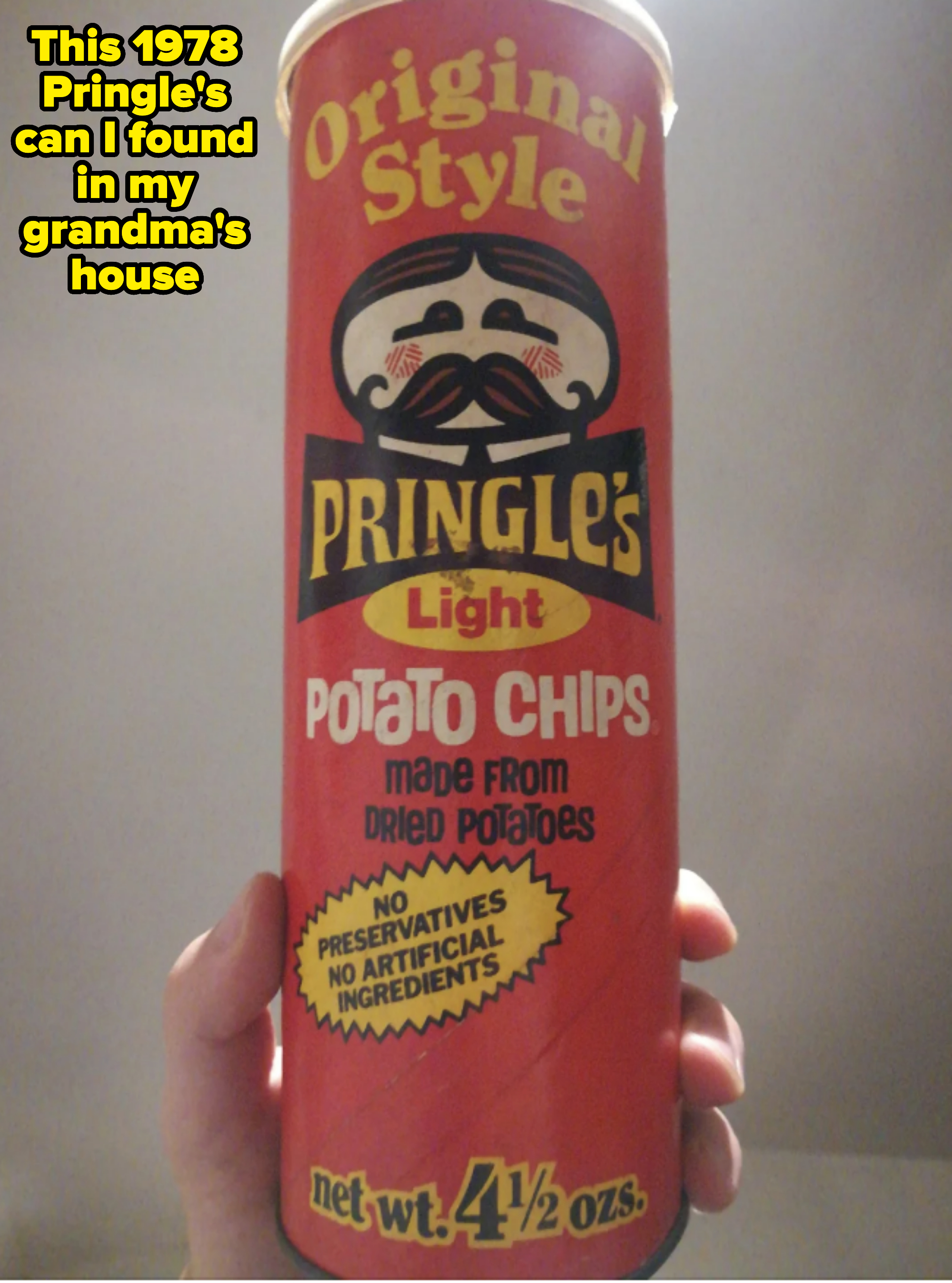 A hand is holding a Pringles can labeled "Original Style" Pringles Light Potato Chips. Text indicates "No preservatives, no artificial ingredients" and "4.5 oz."