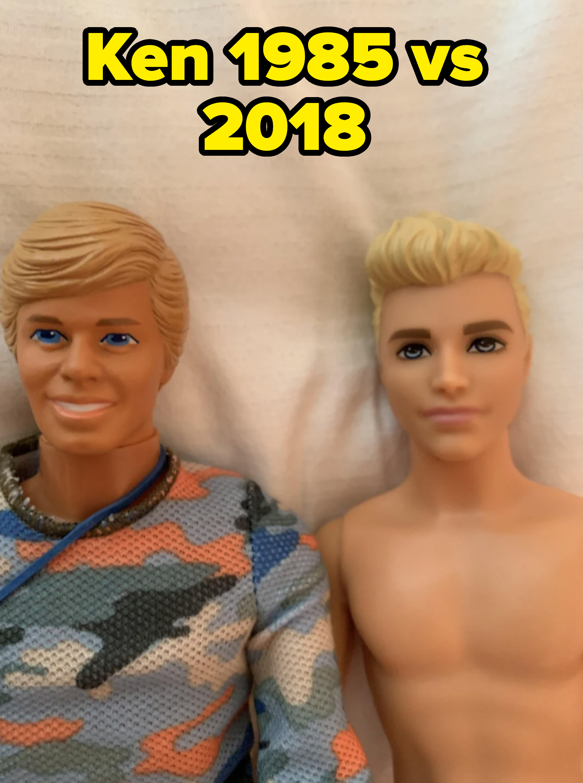 Two Ken dolls, one with a blue camo shirt and necklace, the other shirtless, laying side by side on a white background