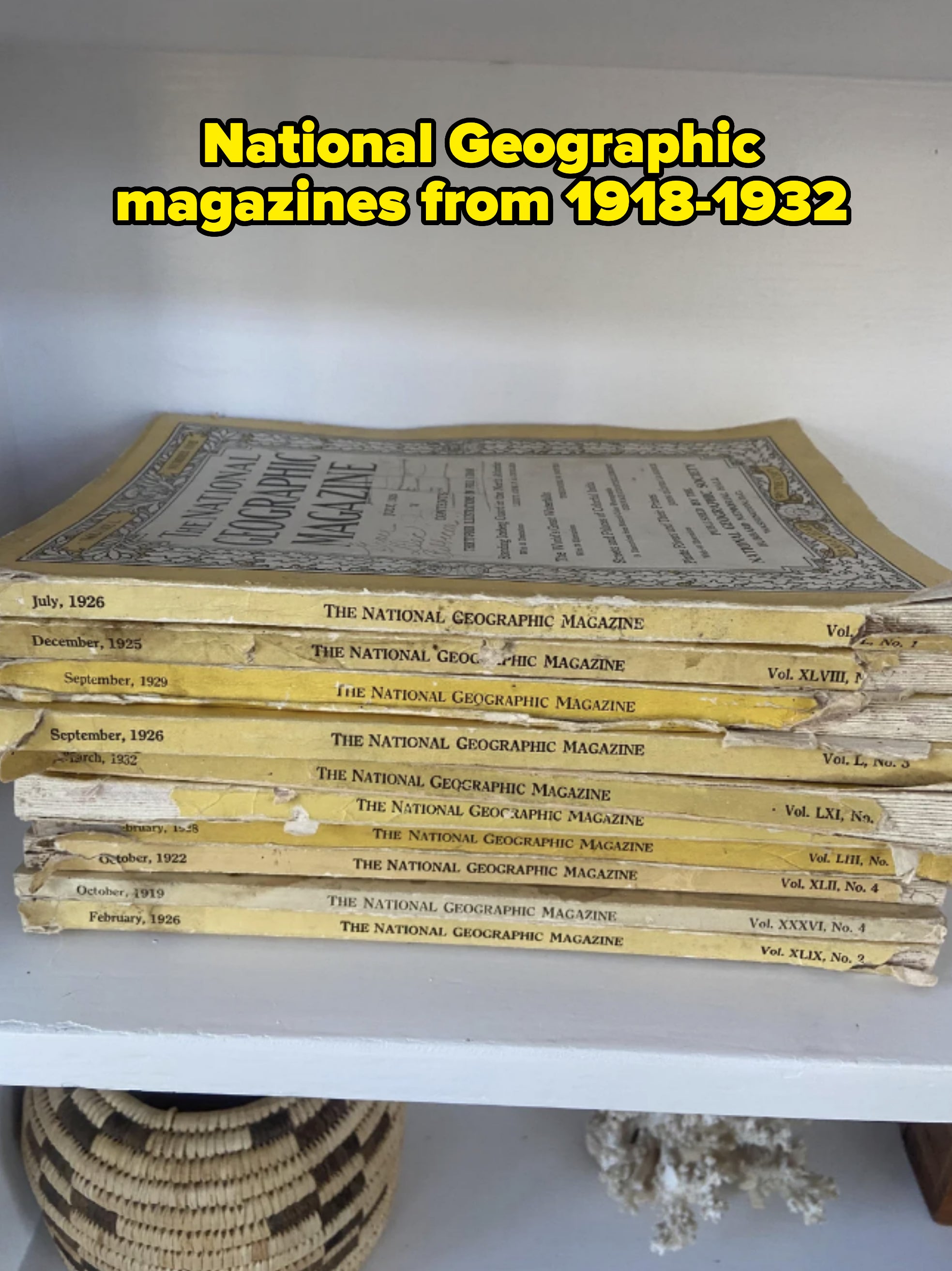 Stack of vintage National Geographic magazines from the 1920s and 1930s on a shelf