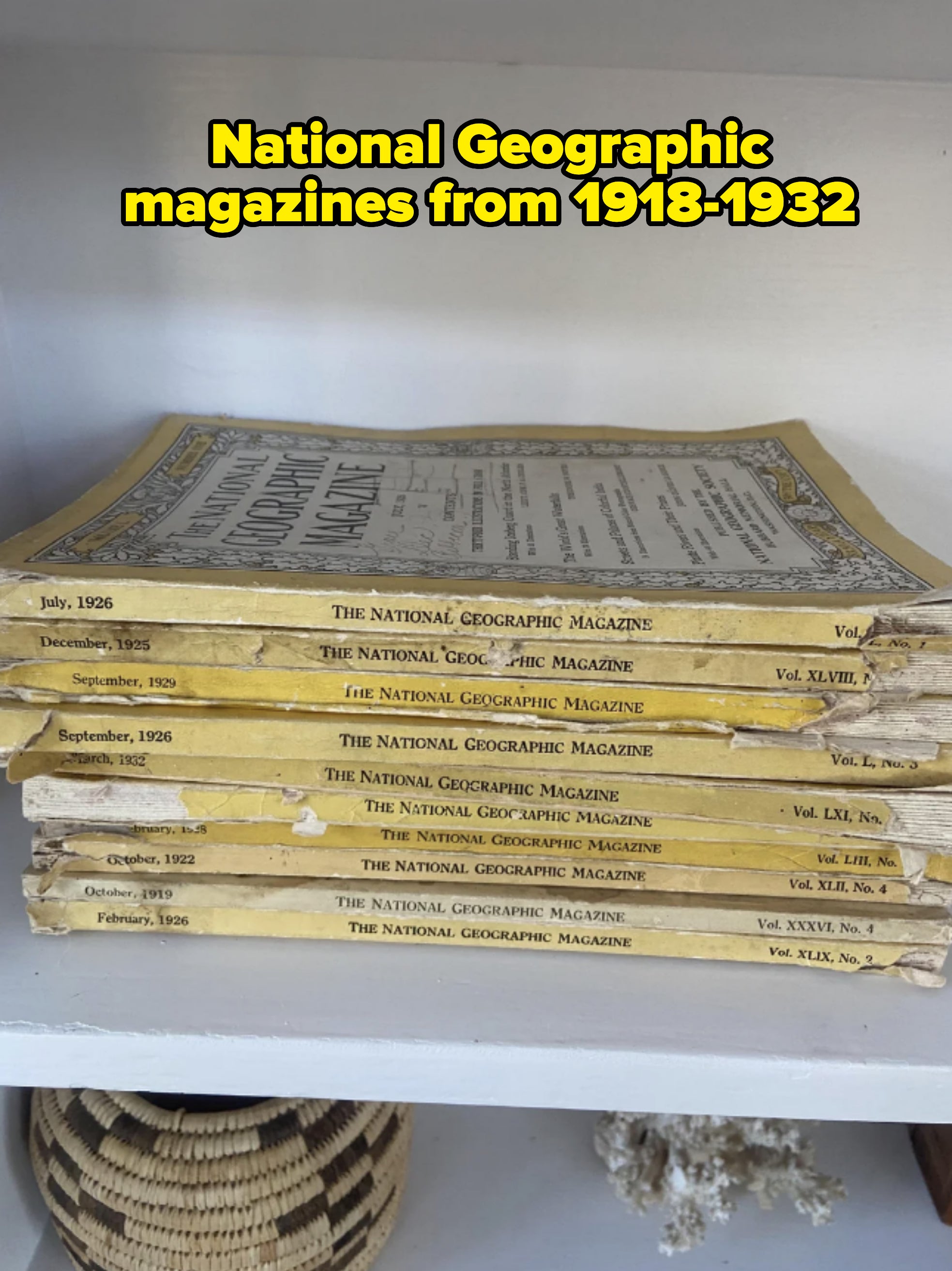 Stack of vintage National Geographic magazines from the 1920s and 1930s on a shelf