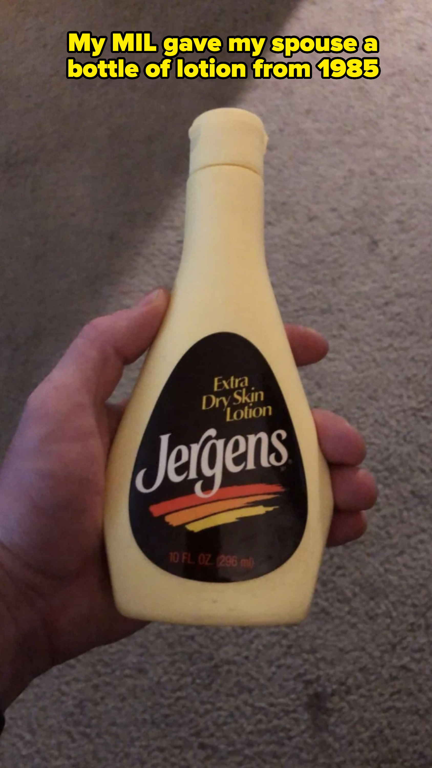 A hand holds a 10 fl. oz. bottle of Jergens Extra Dry Skin Lotion