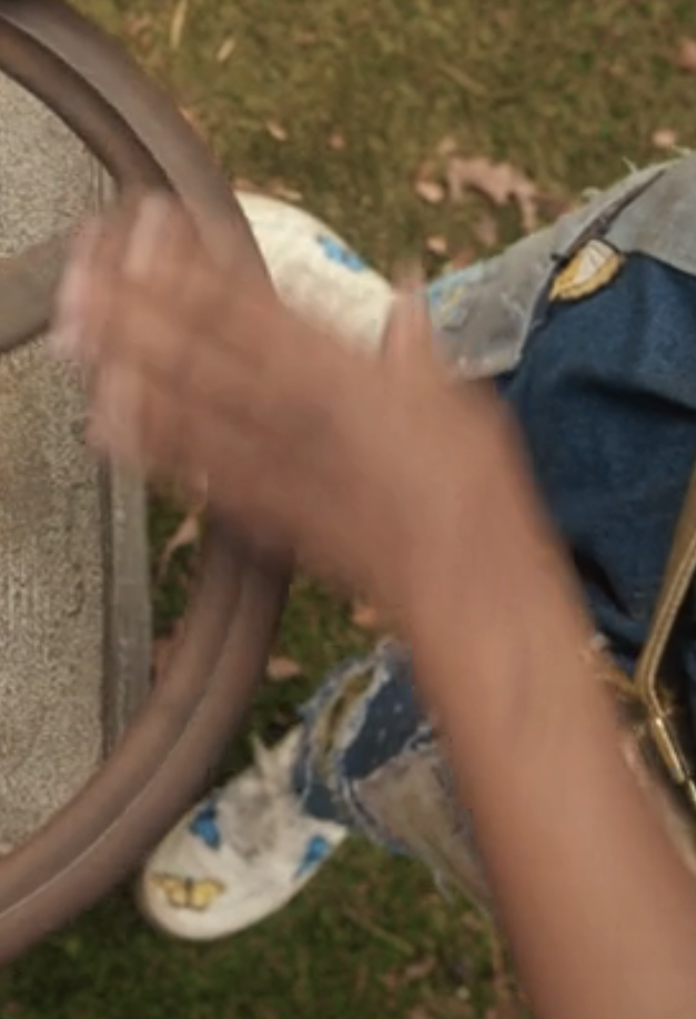 Ella operates an old, weathered wheel mechanism, wearing a stylish, detailed outfit with a gold belt, tennis shoes with colorful butterflies on them